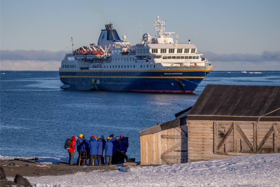 Heritage Expeditions small ship anchored near subantarctic island with wildlife